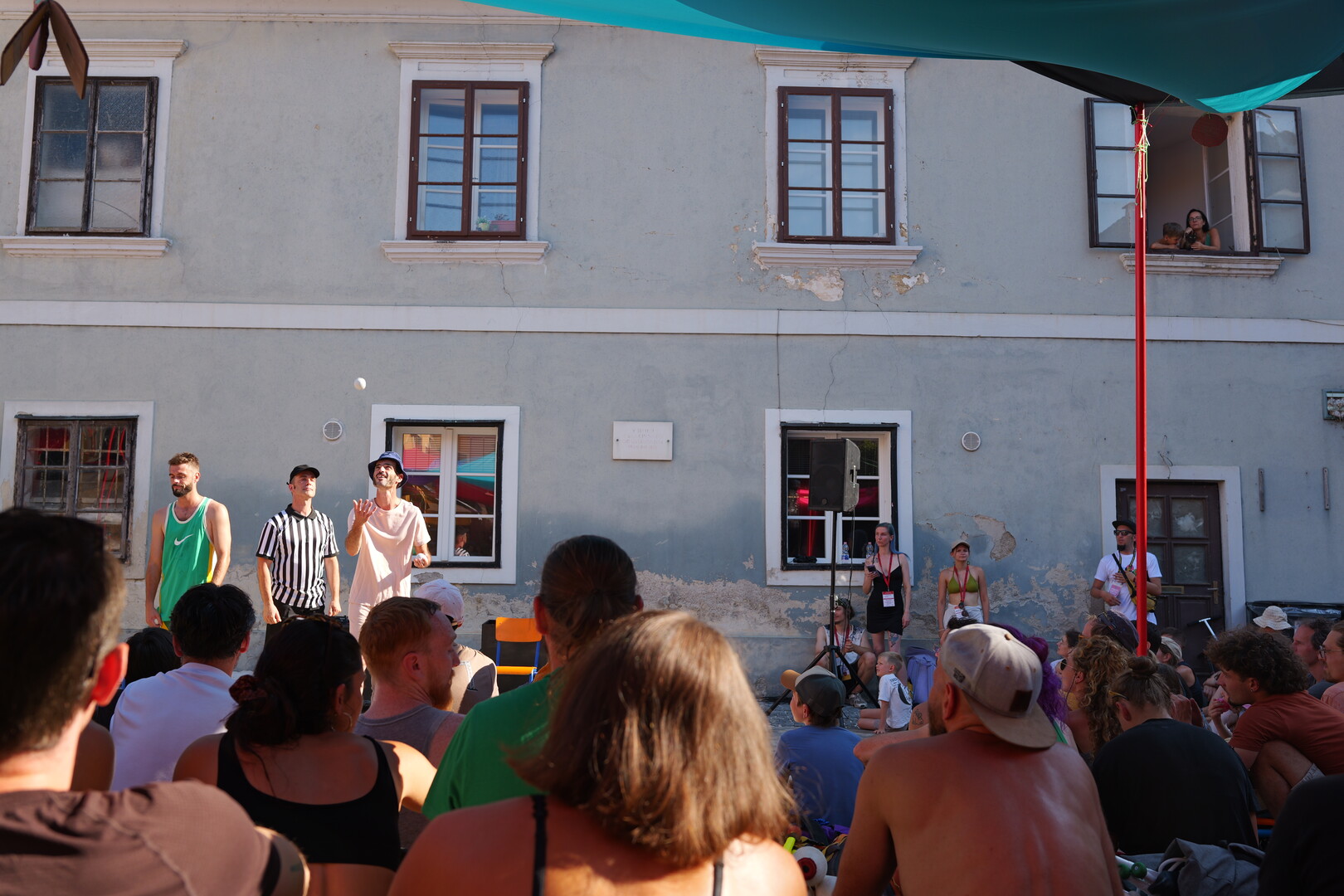Les Objets Volant street show also watched by locals and a cat from a window.